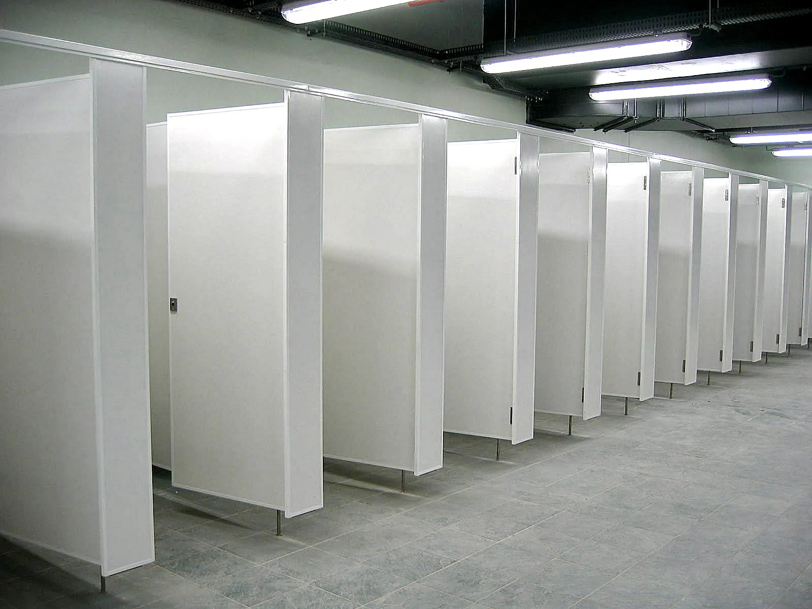 A Vitraflex cubicle installation running the length of an institutional washroom.